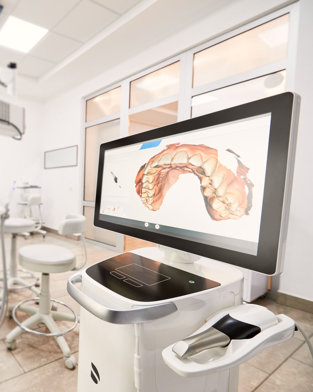 Interior of stomatology cabinet with modern equipment, dental intraoral scanner with teeth on display