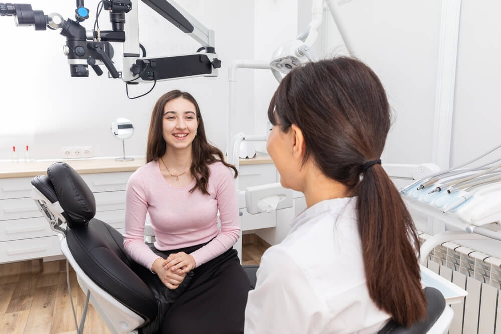 Dentist consulting young patient in dental clinic
