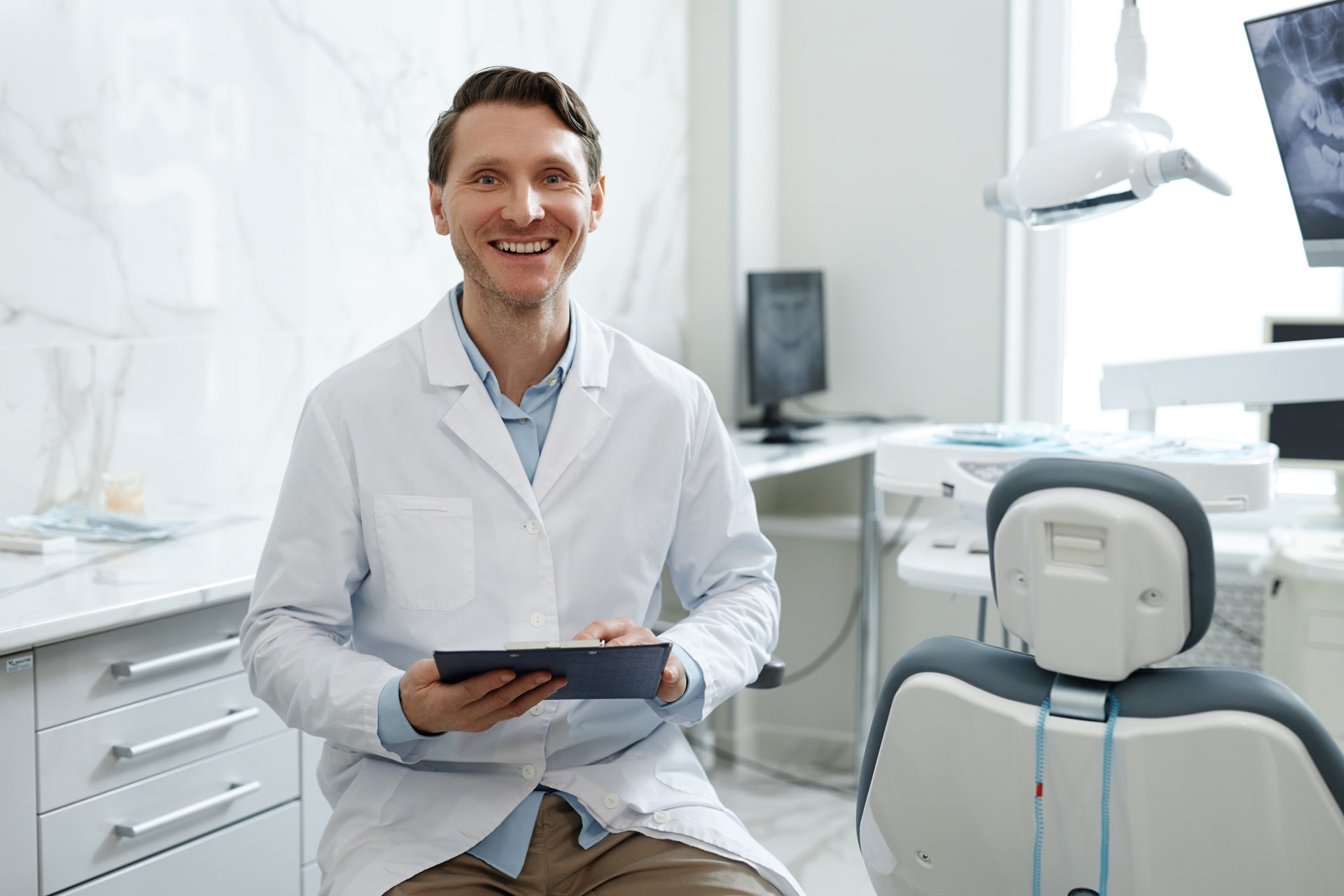 smiling male dentist in dental clinic